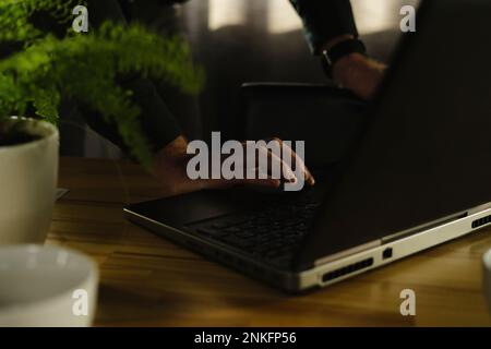Close-up of businessman using laptop on wooden desk Stock Photo