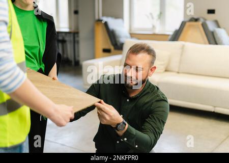 Businessman with engineer examining wooden board in office Stock Photo