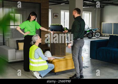Businessman, woman and engineer examining wooden board in office Stock Photo