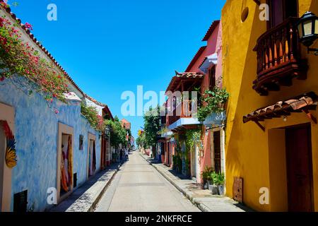Empty street amidst colorful houses under blue sky Stock Photo