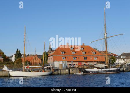 Germany, Schleswig-Holstein, Neustadt in Holstein, Sailing ships moored in front of old granary Stock Photo