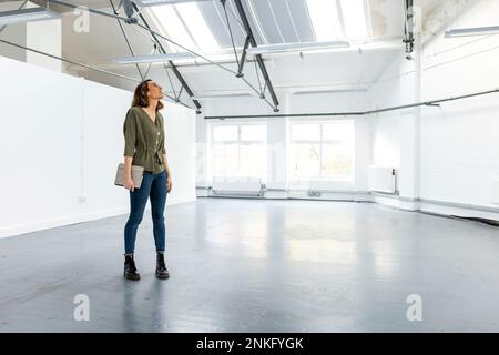 Businesswoman with tablet PC standing in office Stock Photo