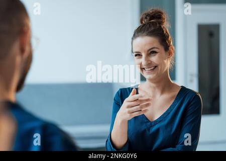 Happy businesswoman talking with colleague at home office Stock Photo