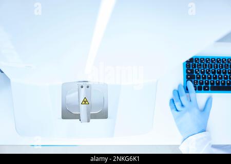 High angle view of scientist's hand and computer keyboard in a lab Stock Photo