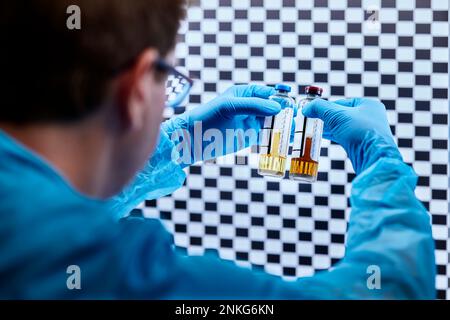 Scientist holding glasses with liquids in a microbiological lab Stock Photo