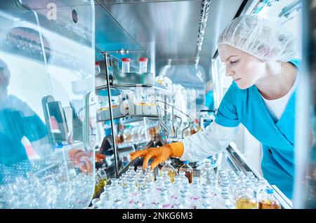 Female scientist working in cleanroom of a microbiological lab Stock Photo