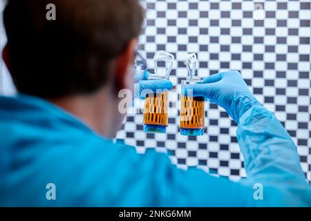Scientist holding glasses with liquids in a microbiological lab Stock Photo
