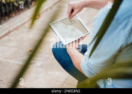 Mature man gesturing on drawing and using tablet PC Stock Photo