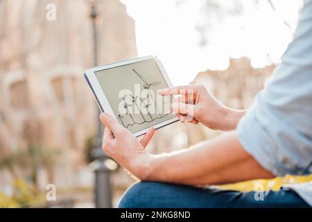 Mature man examining wind turbine diagram on tablet PC Stock Photo