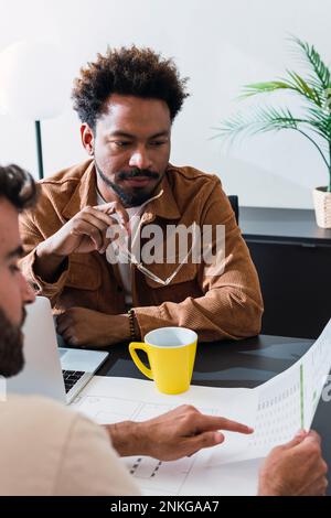 Businessman and colleague discussing over documents Stock Photo