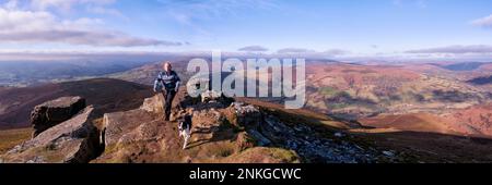 Woman walking with dog on mountain, Sugar Loaf, Brecon Beacons, Wales Stock Photo