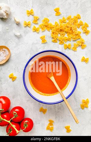 Tomato sauce with raw pasta kept on table Stock Photo