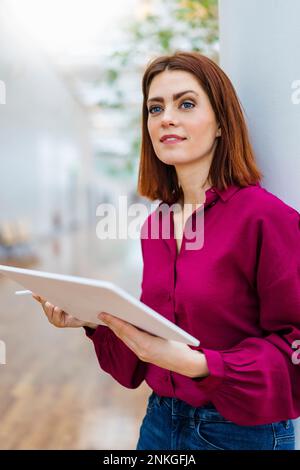 Thoughtful businesswoman holding digital tablet Stock Photo