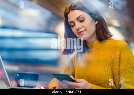 Businesswoman using smart phone in cafe Stock Photo
