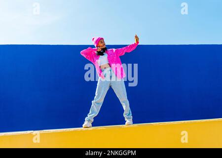 Young woman talking selfie over mobile phone on wall Stock Photo