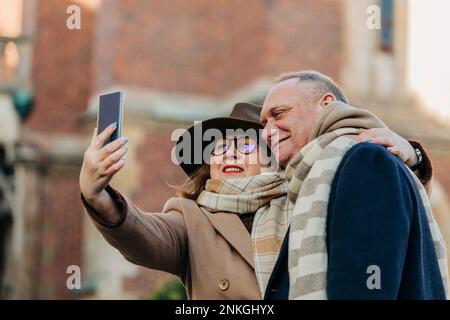 Happy elderly couple taking selfie through smart phone Stock Photo
