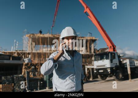 Architect talking on mobile phone at construction site Stock Photo