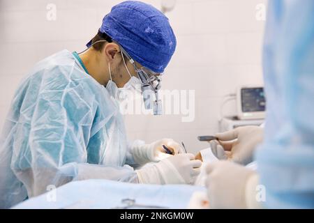 Surgeons performing eye surgery on patient at clinic Stock Photo