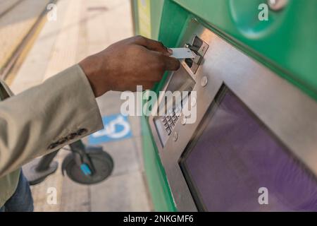 Hand of businessman inserting card in ATM machine Stock Photo