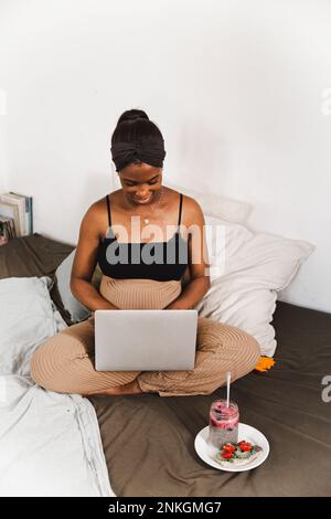 Pregnant woman working on laptop at home Stock Photo