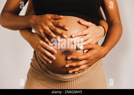Hands of women touching pregnant belly Stock Photo
