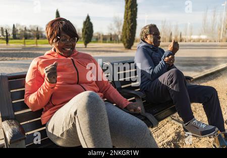 Senior couple sitting on bench at park Stock Photo