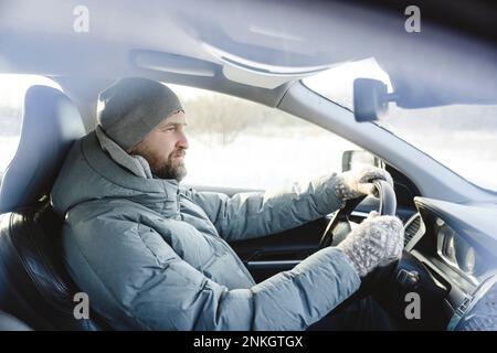 Man wearing knit hat driving car Stock Photo