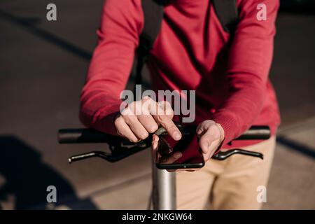 Young man with electric push scooter using smart phone Stock Photo