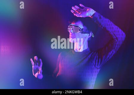 Binary code on woman wearing futuristic glasses against black background Stock Photo