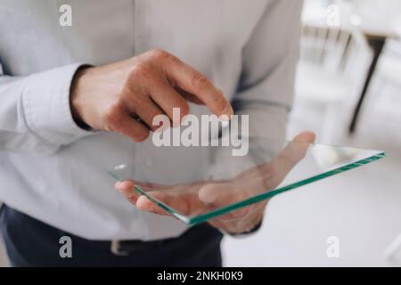 Businessman using futuristic transparent tablet PC Stock Photo