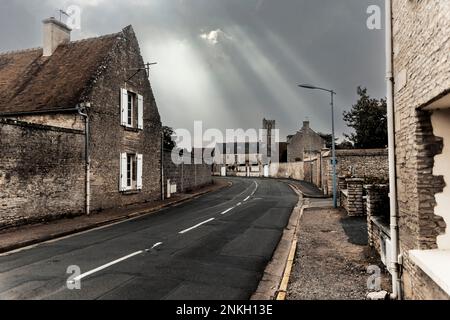 Sunlight streaming through clouds over empty street in old town Stock Photo