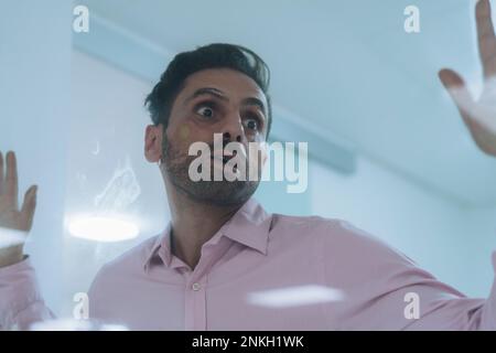 Trapped businessman seen through glass in office Stock Photo