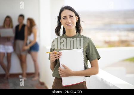 Smiling businesswoman holding spiral notebook Stock Photo