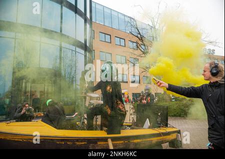 Delft, Netherlands, 22/02/2023, Ocean Rebellions heavy metal band 'Polymetallic Nodules' in a cloud of yellow smoke and using a boat as a stage, sing denouncing the engineering company with lyrics critical of the ocean mining industry and to the environmental damage caused by deep-sea mining. Office workers at 'Allseas Engineering' received an impromptu concert from Ocean Rebellions heavy metal band 'Polymetallic Nodules' while using a boat as a stage. Songs were sang denouncing the engineering company with lyrics critical of the ocean mining industry and to the environmental damage caused by  Stock Photo