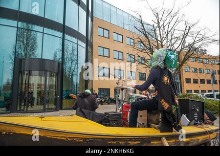 Delft, Netherlands, 22/02/2023, Ocean Rebellions heavy metal band 'Polymetallic Nodules' using a boat as a stage, sing denouncing the engineering company with lyrics critical of the ocean mining industry and to the environmental damage caused by deep-sea mining. Office workers at 'Allseas Engineering' received an impromptu concert from Ocean Rebellions heavy metal band 'Polymetallic Nodules' while using a boat as a stage. Songs were sang denouncing the engineering company with lyrics critical of the ocean mining industry and to the environmental damage caused by deep-sea mining. Allseas was on Stock Photo