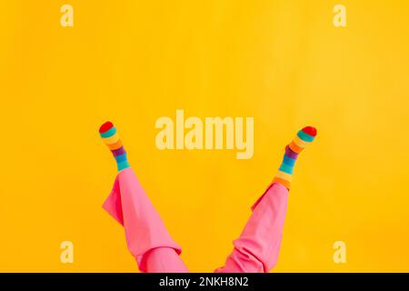 Feet of woman wearing multi colored socks against yellow background Stock Photo
