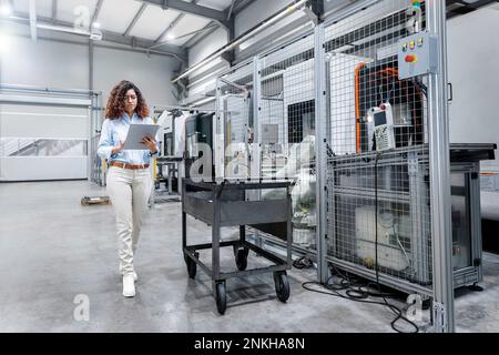 Engineer using tablet PC by machine in industry Stock Photo