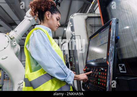 Young engineer operating machinery in factory Stock Photo