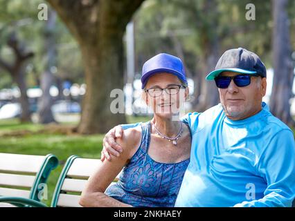 An older senior couple sitting together on a park bench Stock Photo