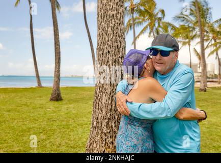 Senior Couple hugging each other in the park near a beach Stock Photo