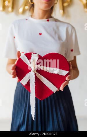 Woman standing with heart shape gift box Stock Photo