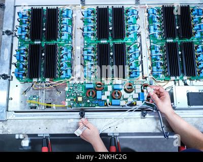 Engineer installing wires on circuit board at factory Stock Photo