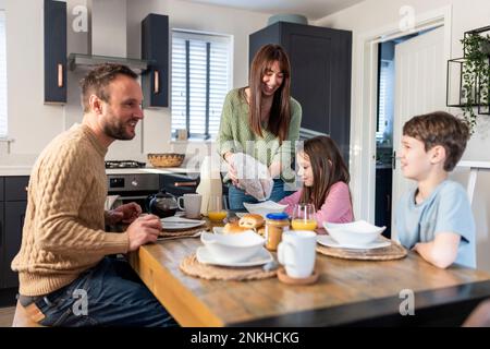 Happy family having breakfast together at table in kitchen Stock Photo