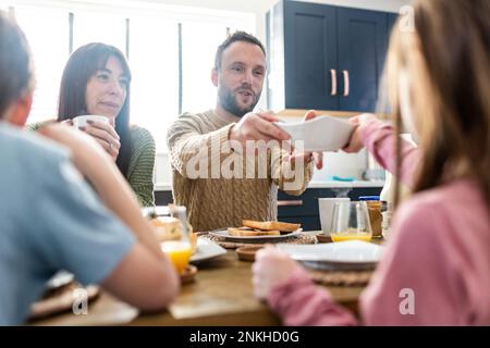 Happy family together having breakfast at home Stock Photo