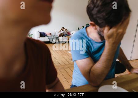 Sibling sitting on sofa in living room at home Stock Photo