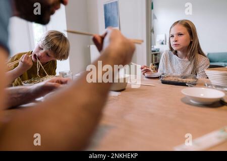 Family eating lunch together on dining table at home Stock Photo