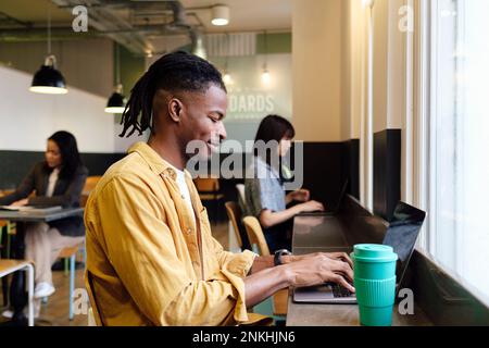 Businessman using laptop sitting at workplace Stock Photo