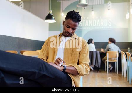 Businessman using smart watch sitting at office Stock Photo