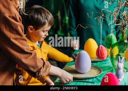 Mother and son decorating Easter dinner table at home Stock Photo