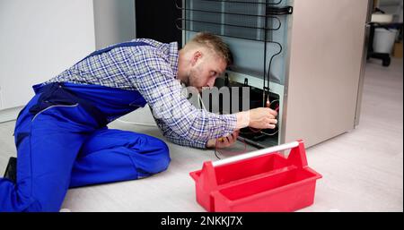 Testing Electric Appliance Using Multimeter To Repair Fridge At Home Stock Photo